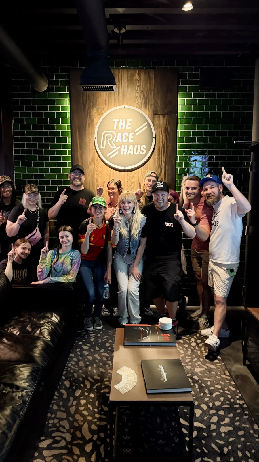Team celebrating together in front of The Race Haus sign